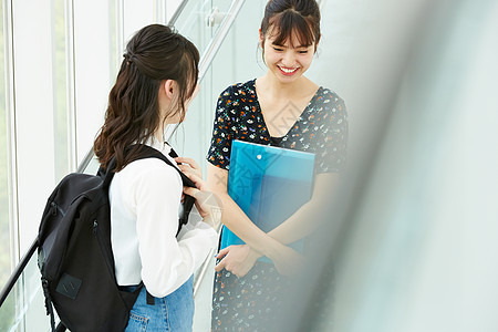 校园里聊天的青年女大学生图片