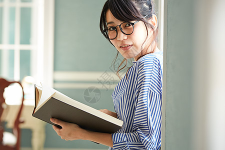 窗边阅读放松的年轻女子图片