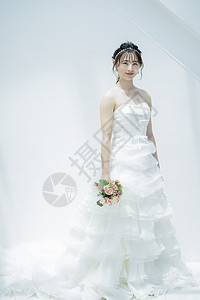 穿着纯白的婚纱拿着手捧花的美女图片