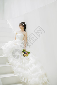台阶上拿着捧花的新娘图片