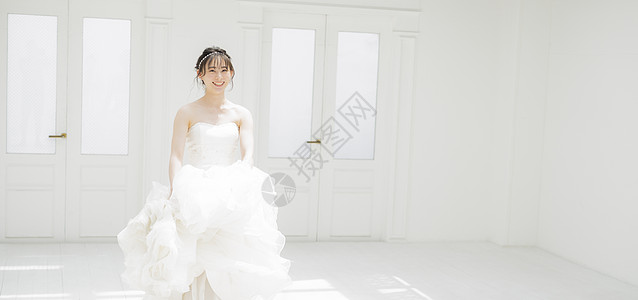 新娘提起婚纱的裙摆微笑图片