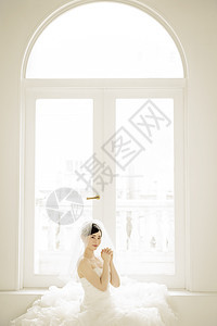 坐在窗边穿着婚纱的新娘图片