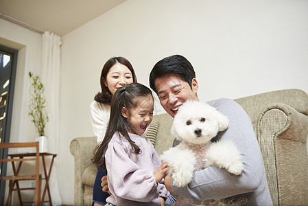 室内抱着宠物狗幸福的一家人图片