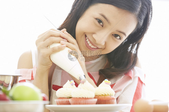 年轻女子制作杯子蛋糕图片