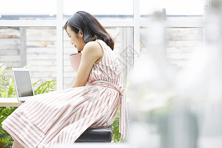 看着笔记本电脑的青年女子图片