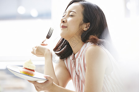 品尝蛋糕开心的年轻女子高清图片