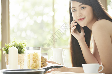 厨房里接听电话的青年女子图片