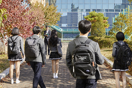 背着书包上学的男女高中生图片素材