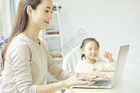 年轻女人在家带孩子居家办公图片