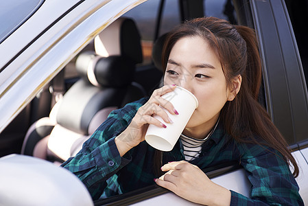 在车上喝水的年轻女人图片