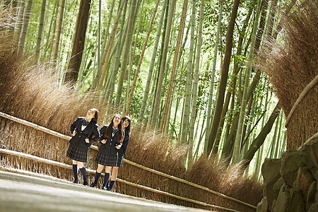 赞助女士学生三个高中女生站在竹林的小直径图片