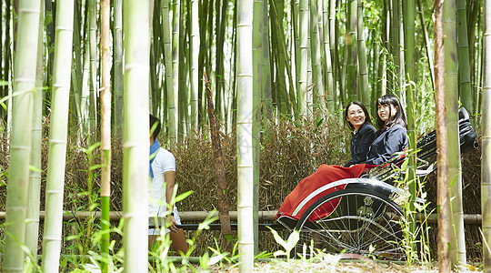 竹林中乘坐人力车的两个高中女孩图片