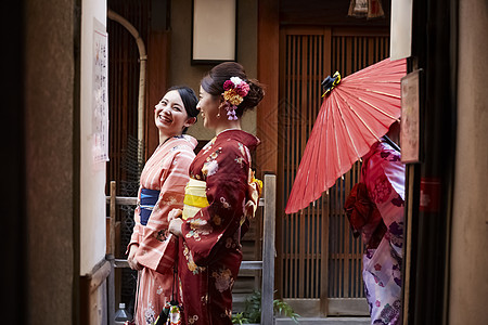 妇女穿着不同的和服在后巷游玩背景图片