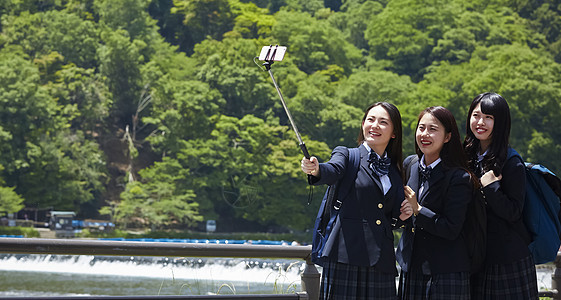 三个背包高中女孩在景点游玩自拍图片