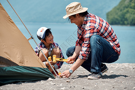 欢闹父母和小孩小学生家庭旅行湖营地图片