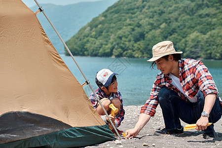 在湖边搭帐篷露营的一家人图片