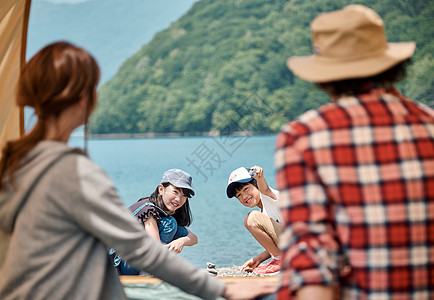 快乐的欢闹家庭湖边扎营地图片