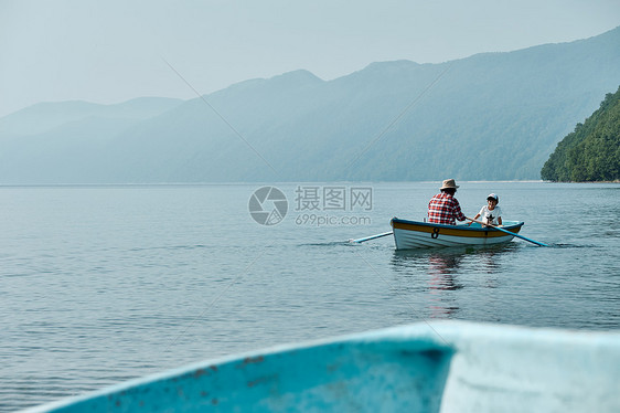 壮年划桨由外向内优良家庭旅行湖船图片