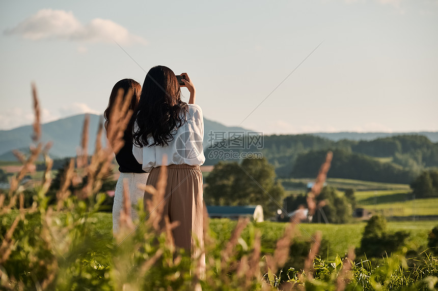 两个女人在户外开心用手机拍照图片