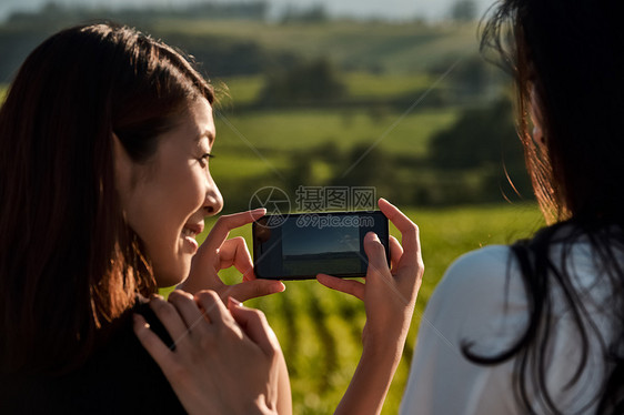 两个女人开心用手机拍照图片