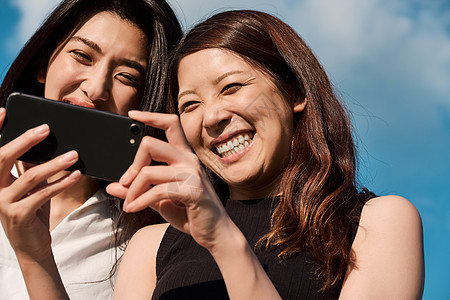 两个女人开心看手机图片