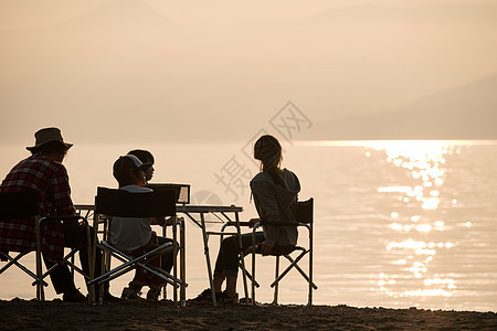 暮色湖边沙滩上露营的一家人图片