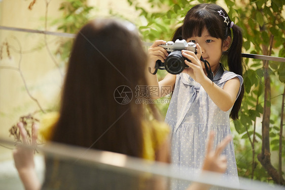 摄影师少女给小女孩拍照图片