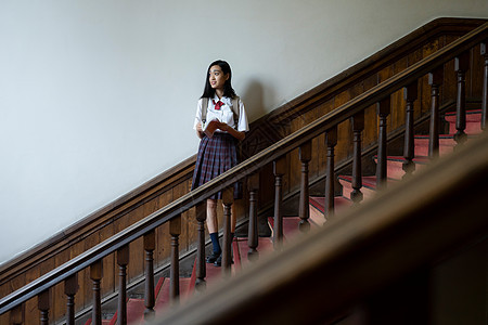 穿校服的女学生在学校里拍照图片