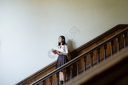 穿校服的女学生在楼梯上拍照图片