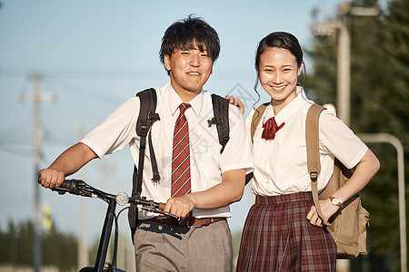 男生帮女生拉拉链放学回家的高中生背景