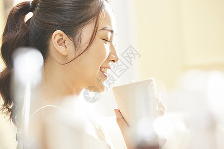 早晨拿着水杯的年轻女子图片