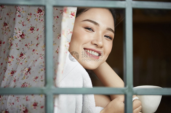 窗边喝咖啡的女性图片