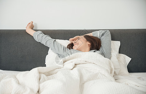 睡衣生活女一个醒着的女人在床上图片素材