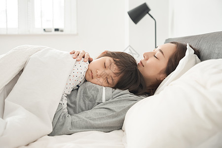 胸像晚安年轻的女孩父母和孩子睡在床上图片