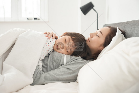 胸像晚安年轻的女孩父母和孩子睡在床上图片