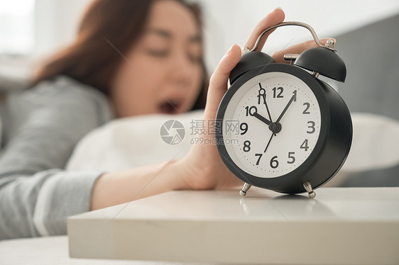 亚洲人休假时钟一个醒着的女人在床上图片