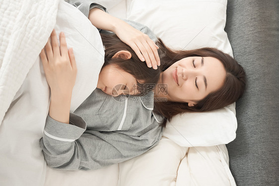 二十几岁女人睡着父母和孩子睡在床上图片