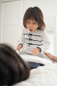 乐趣晚安女孩父母和孩子在床上玩图片