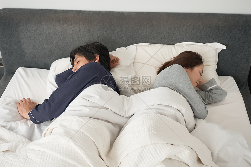 睡在床上的一对夫妇图片