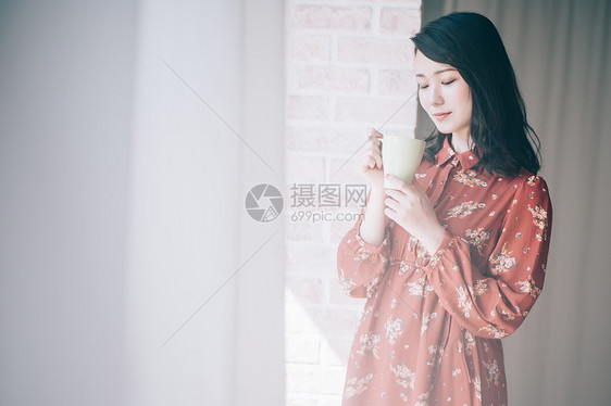 站在窗边的连衣裙美女图片