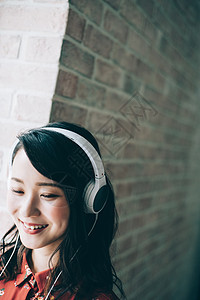 1人天年轻女子用耳机听音乐红色一件女人图片