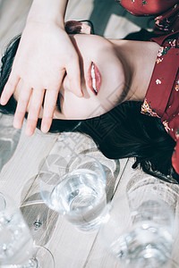 女人耀眼的女生一杯水和红色的一件躺在地板上图片