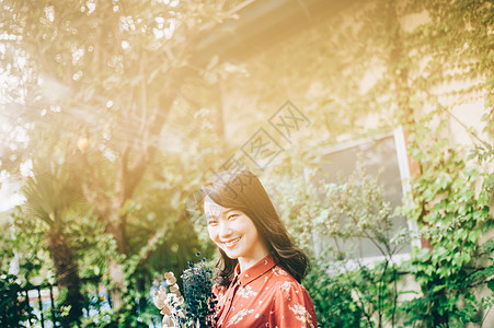 三十几岁日本人插花一个红色的单件女士在花园里的花束图片
