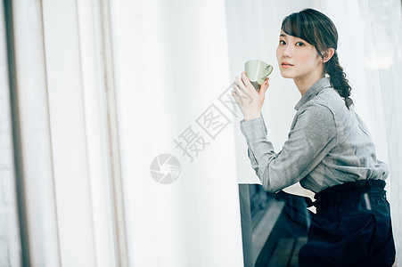 穿灰色衬衫的女孩喝咖啡图片