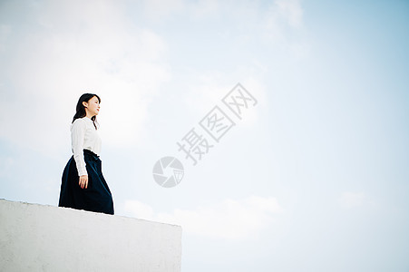 女青年站立在屋顶上图片