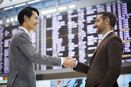亚洲笑脸公告板一位欢迎人们到机场的商人背景图片