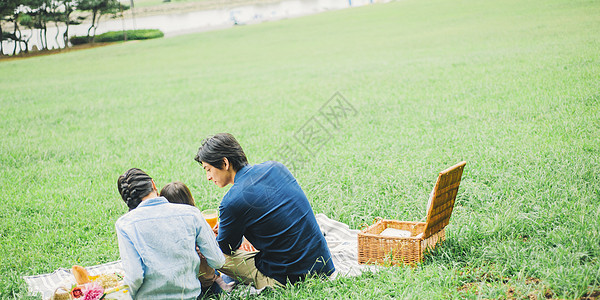 户外一家人在草地上露营吃饭图片