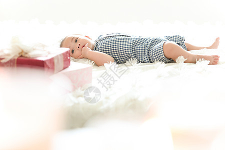 躺在毯子上吃手指的婴儿图片
