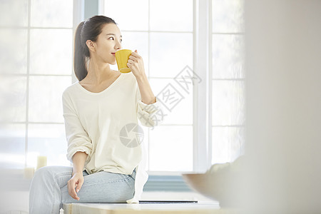 女人端着水杯喝水图片