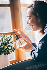 给植物浇水的居家女性图片